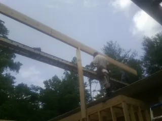 Carpenter setting a ridge beam over a new addition frame — Ice Dam Removal by Roofing Brothers in Truesdale