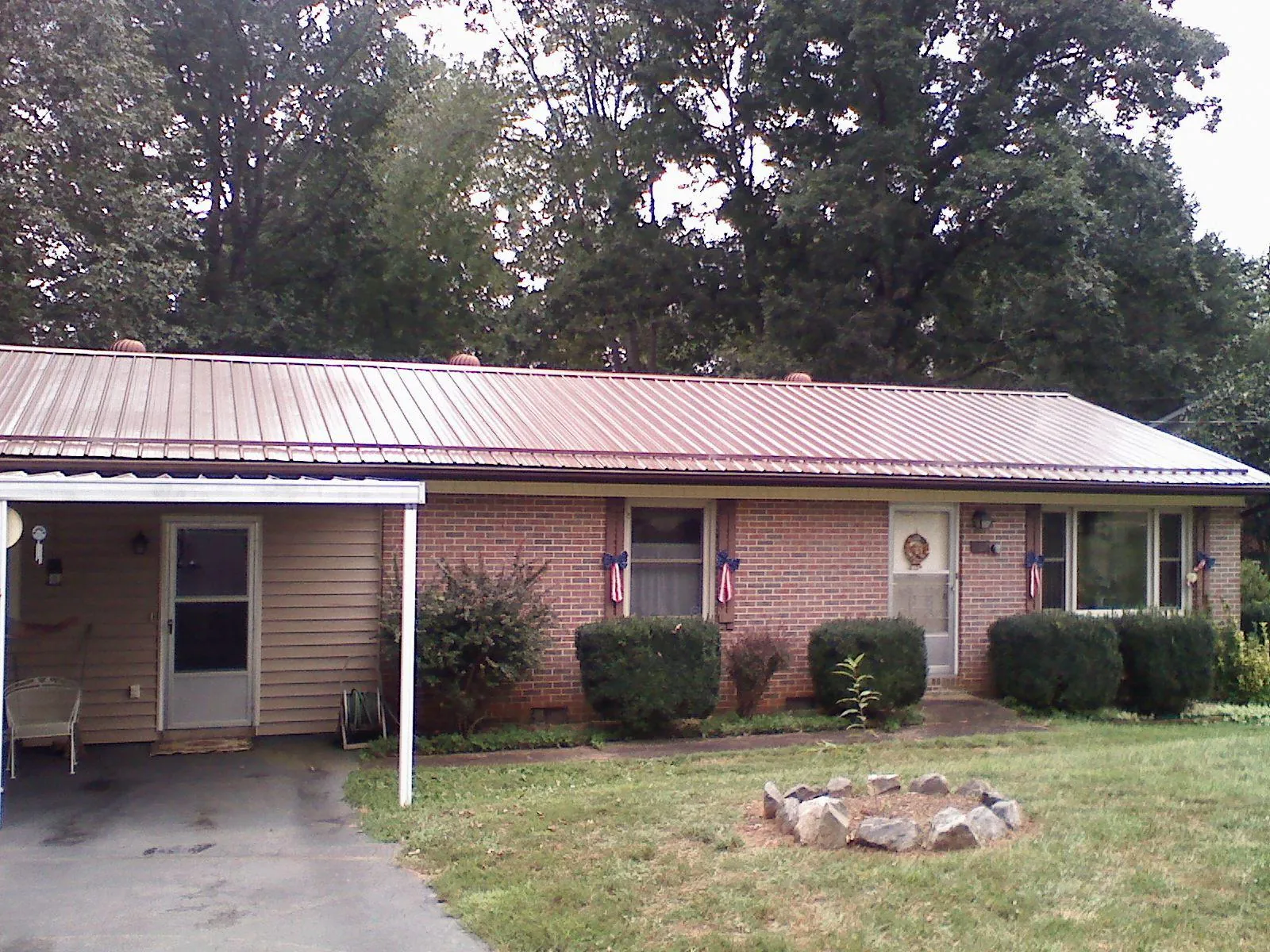Bronze metal roof and carport on a brick ranch home — Roof Repair work by our crew in Truesdale